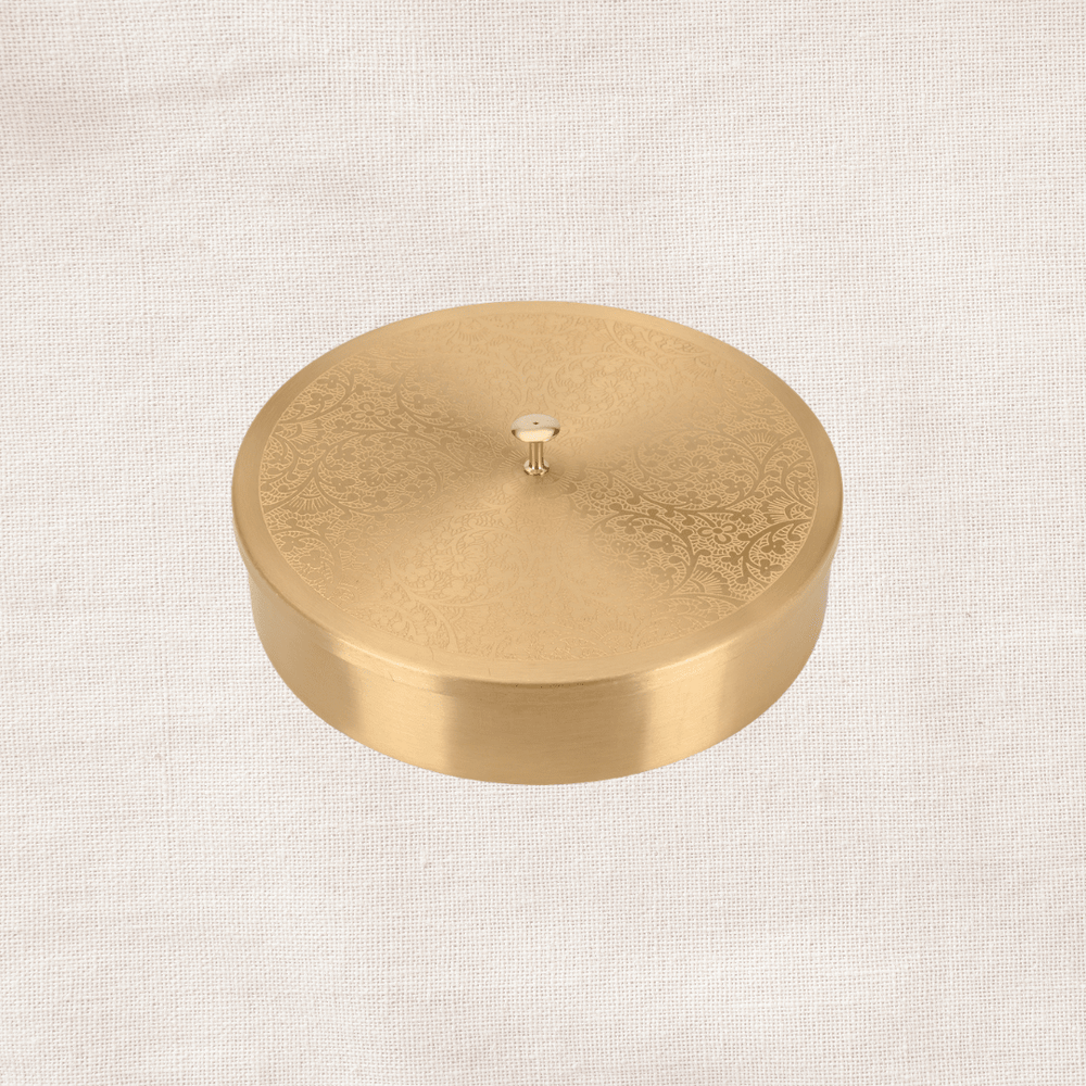 Closed brass masala dabba with flat lid top view