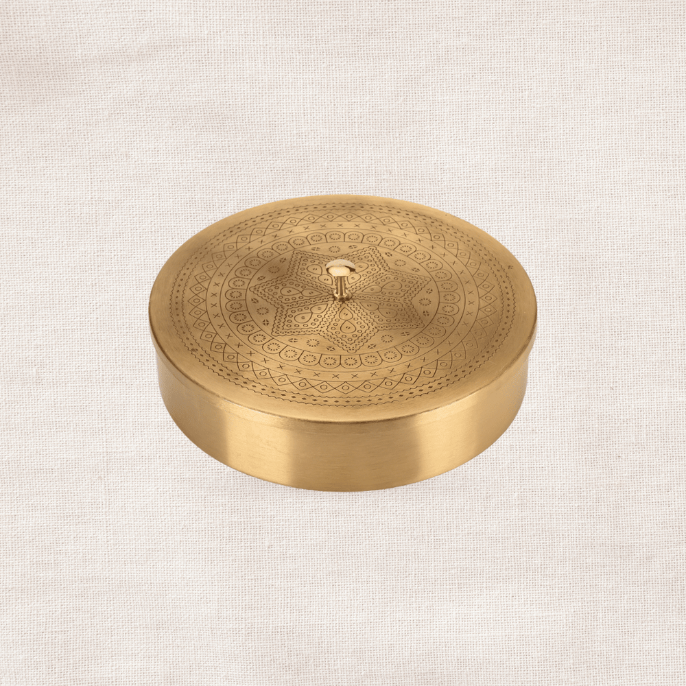 Round handcrafted brass spice box with fitted lid, traditional Indian kitchen storage container.