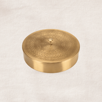 Round handcrafted brass spice box with fitted lid, traditional Indian kitchen storage container.