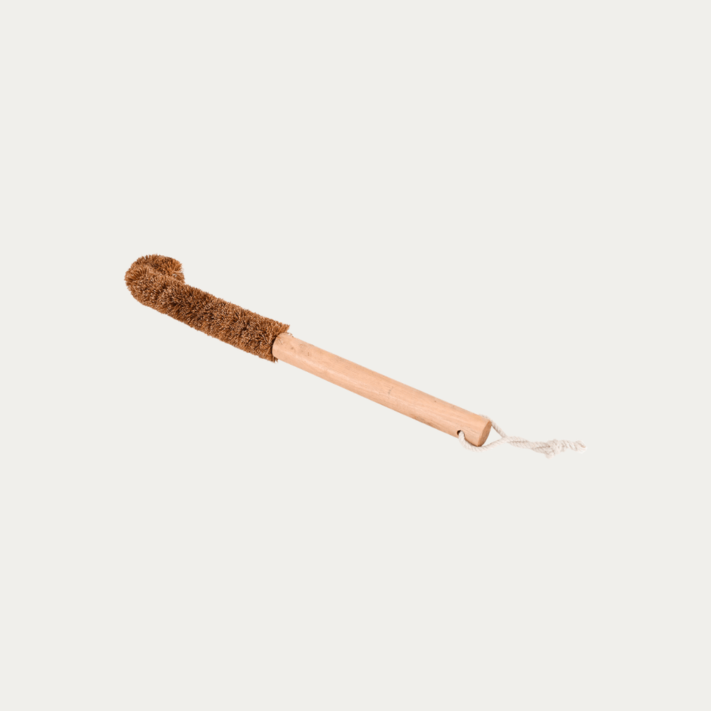 Handcrafted coconut fiber bottle brush with wooden handle for sustainable kitchen and bottle cleaning.