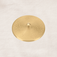 Angled view of engraved brass lid of masala dabba